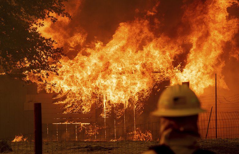 A firefighter monitors a burning outbuilding to ensure flames don’t spread as the River Fire burns in Lakeport, Calif., on Monday, July 30, 2018. A pair of wildfires that prompted evacuation orders for nearly 20,000 people barreled Monday toward small lake towns in Northern California, and authorities faced questions about how quickly they warned residents about the wildfires. (AP Photo/Noah Berger) CANB112 CANB112