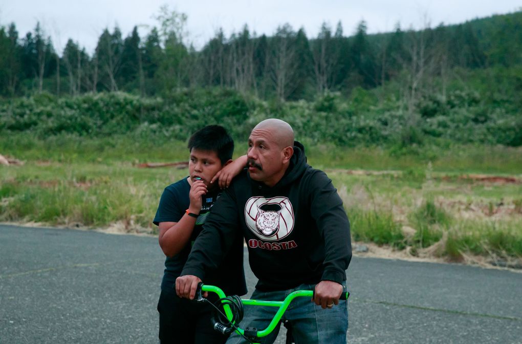 Elyjuh talks with his father, Juan Lopez, in their Hoquiam neighborhood. For years, while wife Erika worked outside the home, Juan has looked after the kids. (Erika Schultz/The Seattle Times)