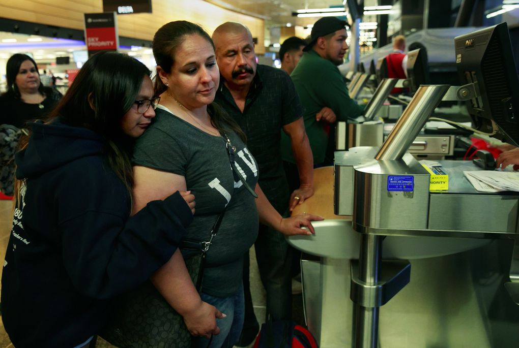 Arainuh Lopez, 11, left, and her parents, Erika and Juan Lopez, wait at the ticket counter at Seattle-Tacoma International Airport as his deportation deadline looms. (Erika Schultz/The Seattle Times)