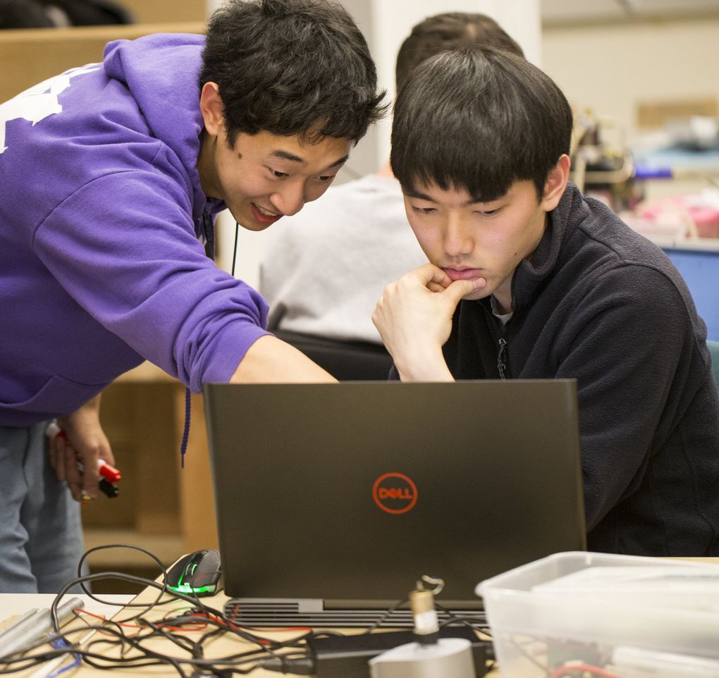 Ryan Chin, left, and Shunsuke Winston, rising seniors in mechanical engineering, work in their lab with the rest of the University of Washington<br/>‘s Advanced Robotics team, which is preparing for the RoboMaster competition in Shenzhen, China. (Bettina Hansen/The Seattle Times)