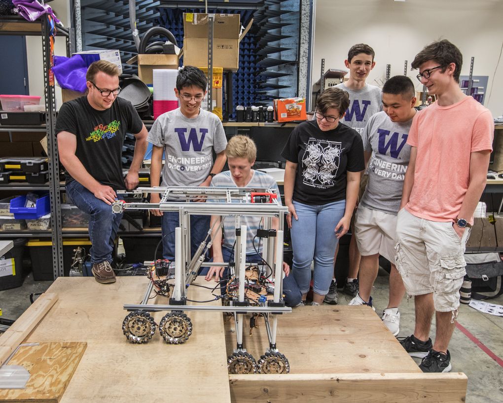 Members of the UW Advanced Robotics team watch as their “engineer” robot — which has an innovative eight-wheel design — gets ready to demonstrate its climbing skills. From left are UW students Jeremy Moon, Khoi Le, Neil Perrin, Christina “JoJo” Durr, Sig Johnson, Frank Liu and Eric de Winter. The team works in a basement lab at UW’s Paul G. Allen Center for Computer Science & Engineering. (Steve Ringman/The Seattle Times)