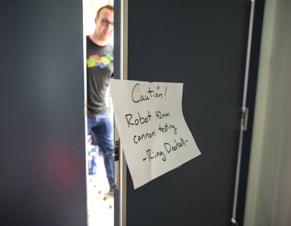 A sign on the door to the robotics lab warns that projectiles are being tested. (Steve Ringman/The Seattle Times)