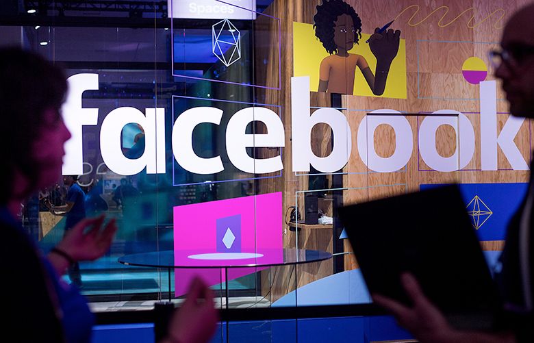 FILE – In this April 18, 2017, file photo, conference workers speak in front of a demo booth at Facebook’s annual F8 developer conference, in San Jose, Calif. One of the congressional committees investigating Russiaâ€™s interference in the 2016 election has invited the tech giants Facebook, Twitter and the parent company of Google to appear for a public hearing on Nov. 1. (AP Photo/Noah Berger, File)