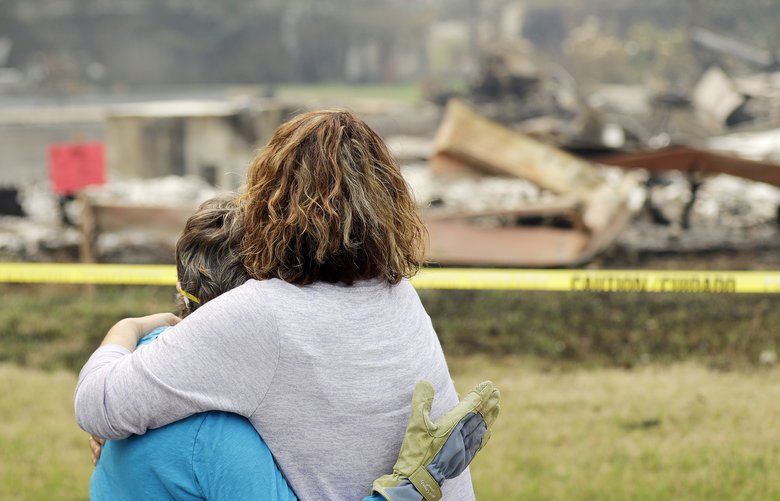 Carol Smith, left, gets a hug from her daughter Suzie Scatena, after seeing her fire-ravaged home for the first time Thursday, Aug. 2, 2018, in Redding, Calif. (AP Photo/Marcio Jose Sanchez) CAMS102 CAMS102