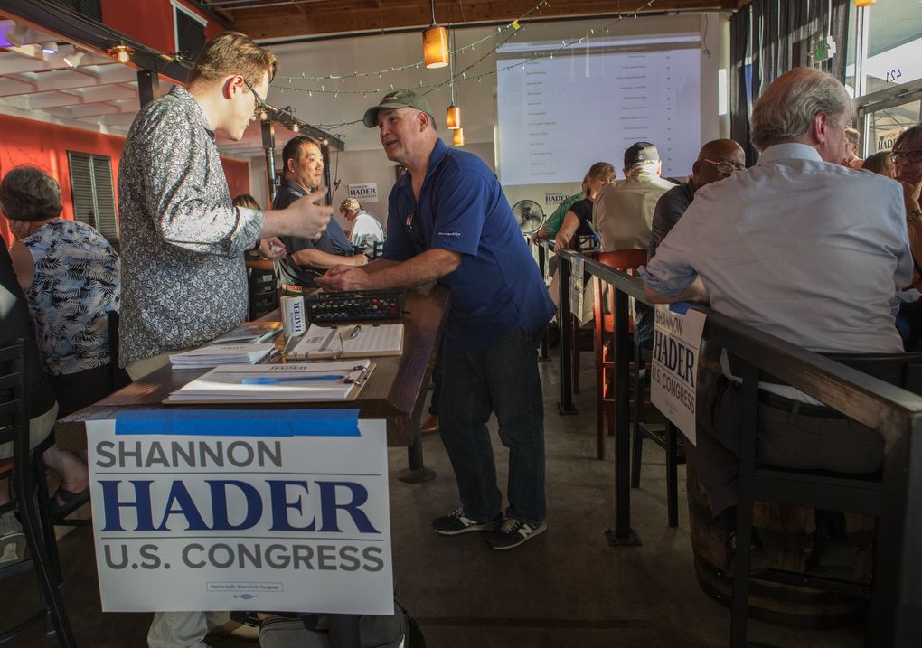 Jim Dettman from Snoqualmie, right, speaks with Winfield Salyards, an associate fundraiser for Shannon Hader, at Geaux Brewery in Auburn. (Ellen M. Banner / The Seattle Times)