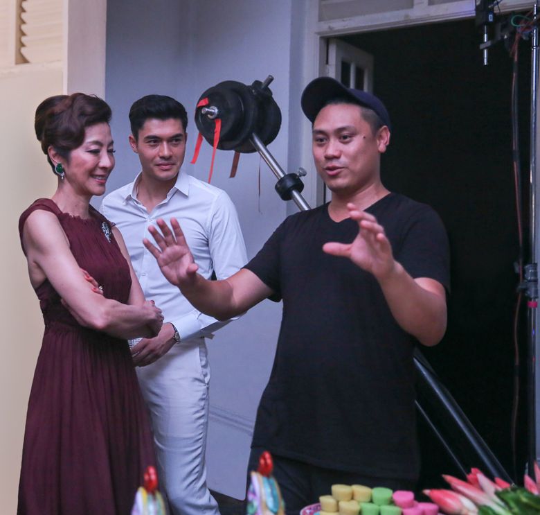 Michelle Yeoh, Henry Golding, center, and director Jon M. Chu on the set of “Crazy Rich Asians.”(Sanja Bucko)