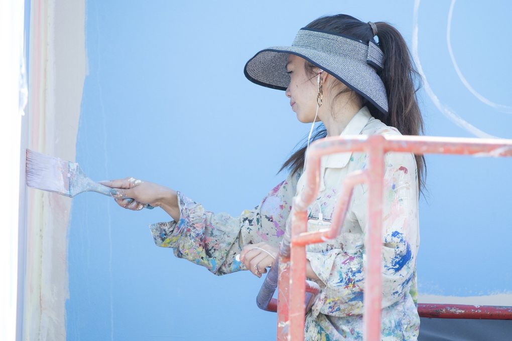 San Diego artist Celeste Byers, who got her start as a muralist painting a wall of an airplane hangar, works on her mural along the SODO Track. (Bettina Hansen / The Seattle Times)