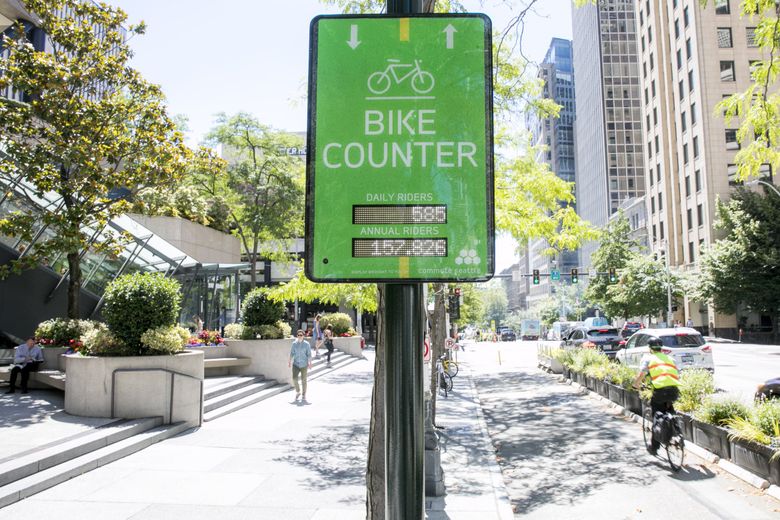 A cyclist passes by the bike counter on Second Avenue between Madison and Marion Streets in downtown Seattle  on Thursday, July 12. (Bettina Hansen / The Seattle Times)