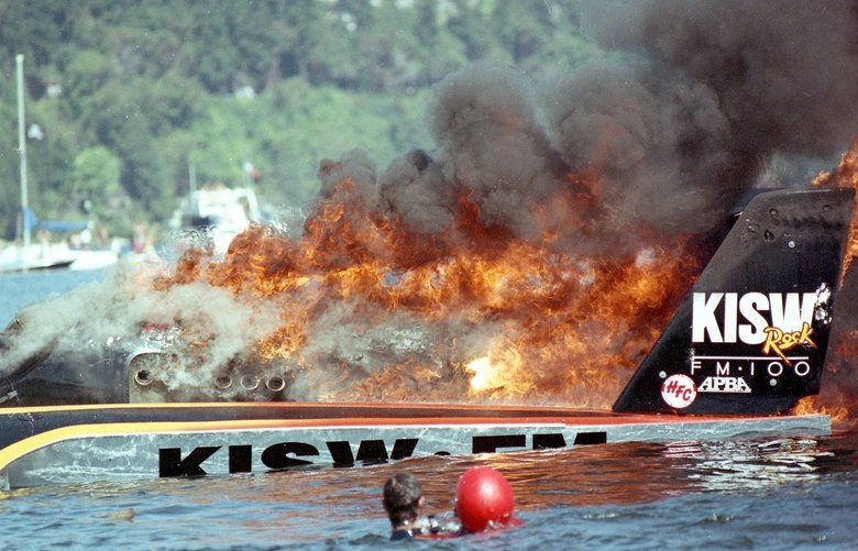 The Miss Rock KISW is engulfed in flames in the south turn of the Seafair unlimited hydroplane race course, Friday, August 3, 1990. The driver, Jack Barrie, wearing red helmet, is in the foreground being aided by a rescue diver, to the left of Barrie. The hydroplane ignited as it attempted to qualify for tomorrow’s race. The driver said he was unaware of the fire at first, which occurred after his engine died. Barrie was not injured. The crew plans to attempt to qualify tomorrow if the boat can be repaired in time. If he was hurt, Jack Barrie did not show it after a fire to Miss Rock put a momentary halt to his chances of qualifying for the Seafair unlimited hydroplane regatta, Friday, August 3, 1990.