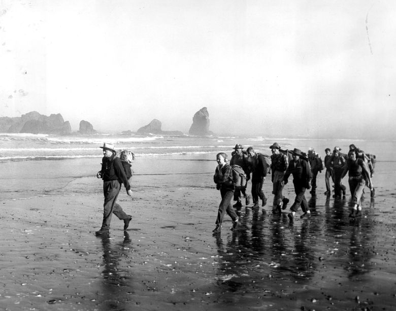 In 1958, U.S. Supreme Court Justice William O. Douglas led a 22-mile hike along the northern Washington coast to protest a proposed extension of Highway 101. Rocks appear just off the shoreline as Douglas leads the way to Rialto Beach. His wife, Mercedes, is behind him. The planned highway extension was never built. (The Seattle Times, 1958)