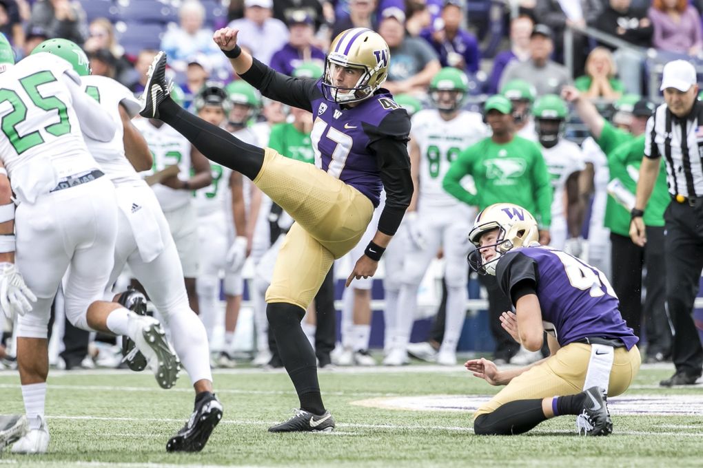 Huskies place kicker Peyton Henry, with punter Race Porter holding. (Bettina Hansen / The Seattle Times)