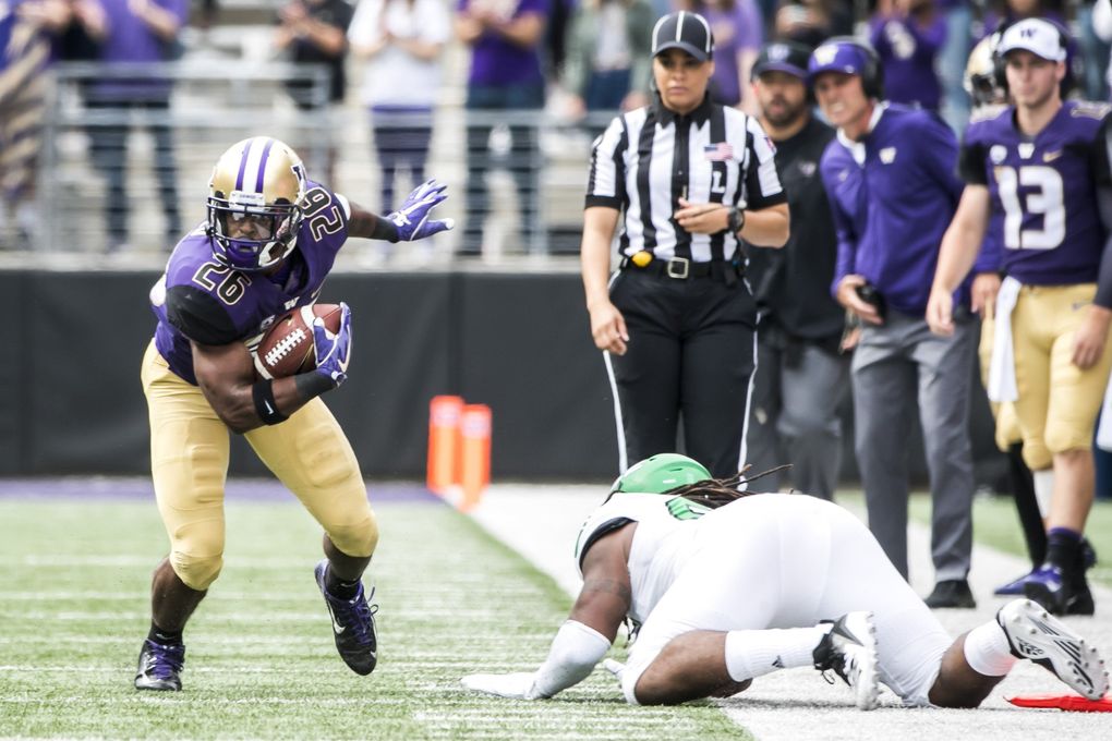 Huskies running back Salvon Ahmed picks up 12 yards and a first down, ditching Fighting Hawks linebacker Everett Williams in the first quarter, as the University of Washington Huskies take on the North Dakota Fighting Hawks for their home opener at Husky Stadium in Seattle Saturday September 8, 2018. (Bettina Hansen / The Seattle Times)