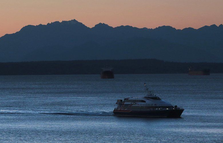 Seattle, Wa  – 143066 – gg –  11/11/2014  –  LO LO LO  – The Victoria Clipper IV prepares to dock at Pier 69 in downtown Seattle, with a backdrop of the Olympic Mountains at sunset.