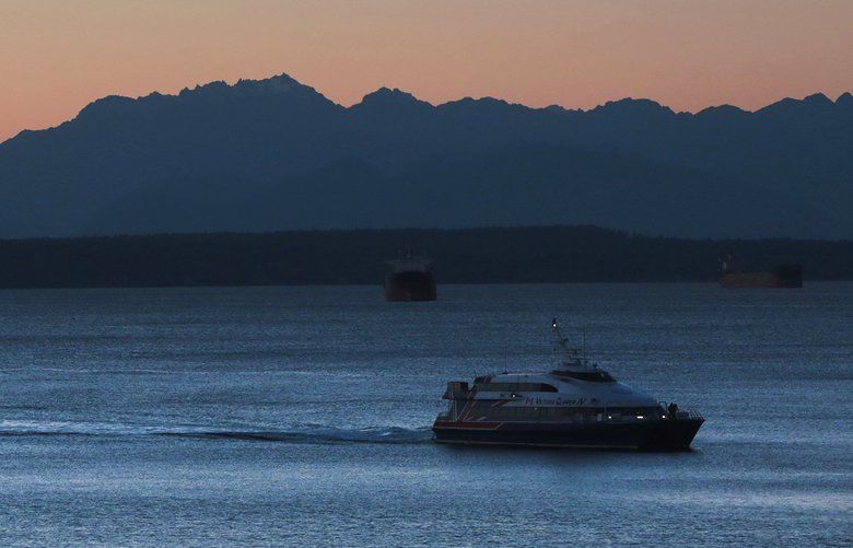 Seattle, Wa – 143066 – gg – 11/11/2014 – LO LO LO – The Victoria Clipper IV prepares to dock at Pier 69 in downtown Seattle, with a backdrop of the Olympic Mountains at sunset.