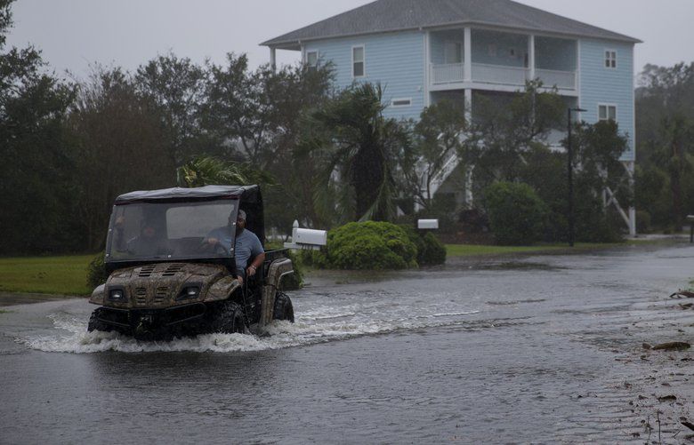 People drive along a flooded area as Hurricane Florence swept through the area in Wilmington, N.C., on Sept. 14, 2018. Florence, lashing the North Carolina coast with strong winds and blinding rain, made landfall Friday morning having already driven dangerous storm surges of several feet into beach and river towns. The eye of the storm came ashore at Wrightsville Beach, N.C., just east of Wilmington, with winds of about 90 miles an hour. (Eric Thayer/The New York Times) XNYT4 XNYT4