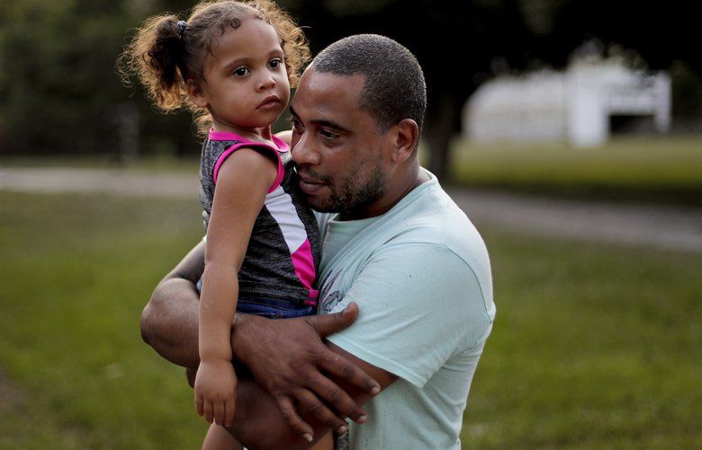 Jose Perez-Santiago, right, holds his daughter Jordalis, 2, as they return to their home for the first time since it was flooded in the aftermath of Hurricane Florence in Spring Lake, N.C., Wednesday, Sept. 19, 2018. “I didn’t realize we would lose everything,” said Perez-Santiago. “We’ll just have to start from the bottom again.” (AP Photo/David Goldman) NCDG136 NCDG136