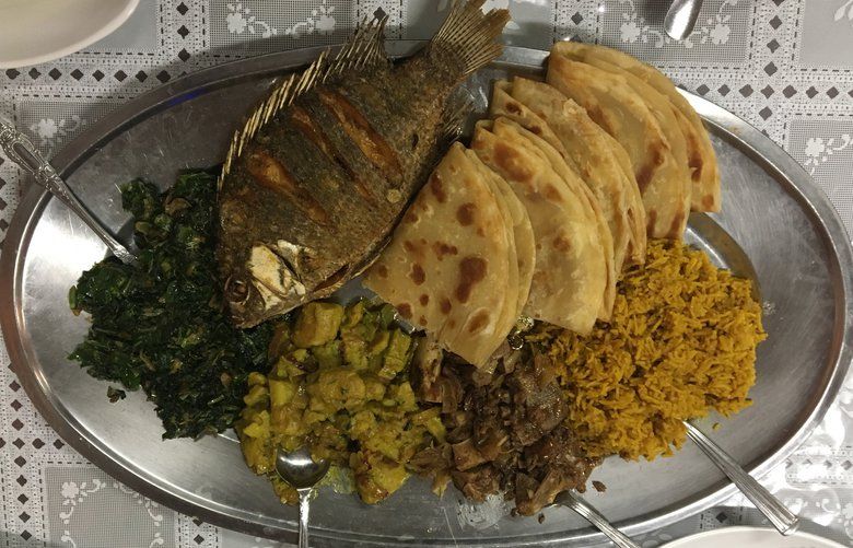The samaki (tilapia) and mbuzi (goat), accompanied by pilau, sukuma mix (collard greens & spinach), matoke (green banana) and chapati (Kenyan flat bread) at Safari Restaurant, served at once on a single platter.