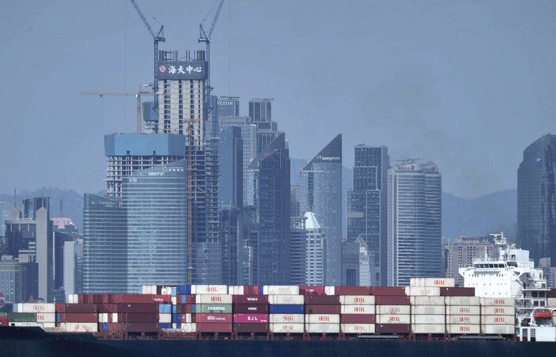 In this Sept. 13, 2018, photo, a container ship sails past the city skyline of Qingdao in eastern China’s Shandong province. China raised tariffs Monday, SEPT. 24 on thousands of U.S. goods in an escalation of its fight with President Donald Trump over technology policy and accused Washington of bullying Beijing and damaging the global economy. (Chinatopix via AP) XAW802 XAW802