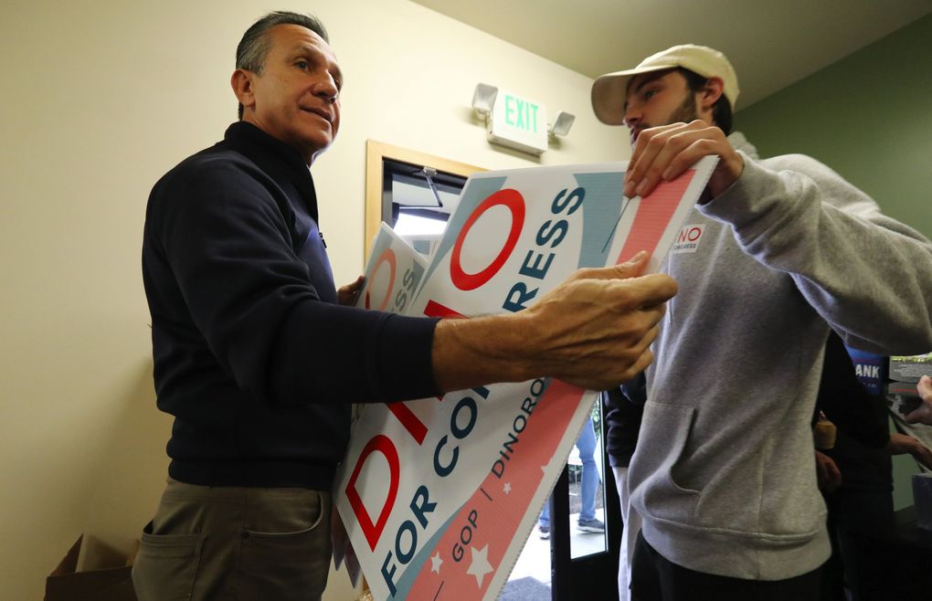 Republican House of Representatives candidate Dino Rossi, left, with field organizer Carson Coates gathers up signs at Rossi’s office in Issaquah before an afternoon of doorbelling in the district. Coates is with the state Republican party. (Alan Berner / The Seattle Times)