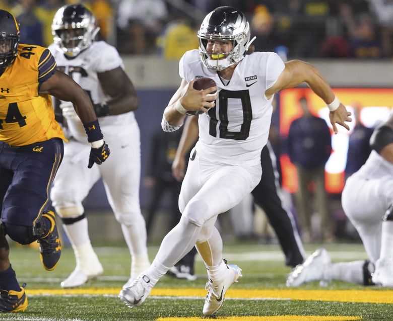 Justin Herbert of the Oregon Ducks looks to pass against the in