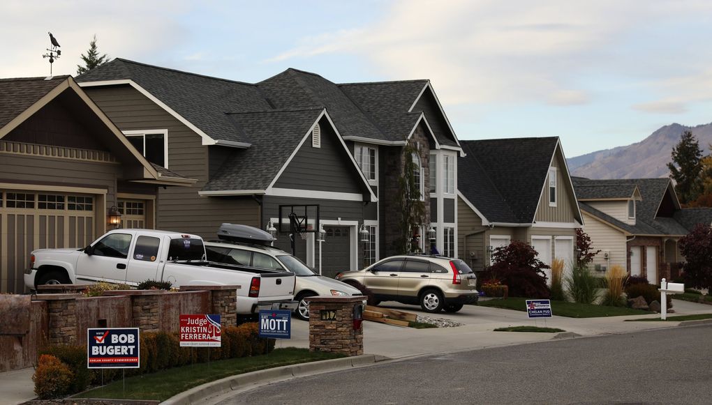 Political signs dot the curb in a Wenatchee neighborhood, (Ken Lambert / The Seattle Times)