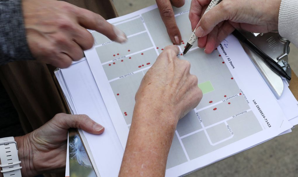 Canvassers go over a doorbelling map for the 8th congressional and 12th legislative districts. (Ken Lambert / The Seattle Times)