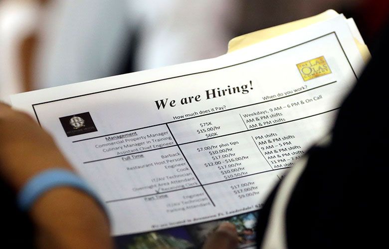 In this June 21, 2018, file photo, a job applicant looks at job listings for the Riverside Hotel at a job fair hosted by Job News South Florida, in Sunrise, Florida.(Lynn Sladky / The Associated Press)