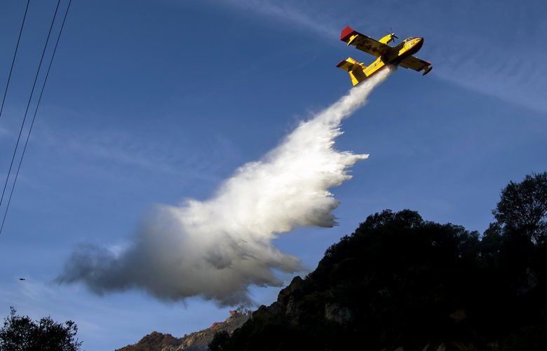 An air tanker drops water on a fire in Malibu Canyon, Calif., on Tuesday morning, Nov. 13, 2018. The Woolsey Fire has charred more than 96,000 acres. (Eric Thayer/The New York Times) XNYT97 XNYT97