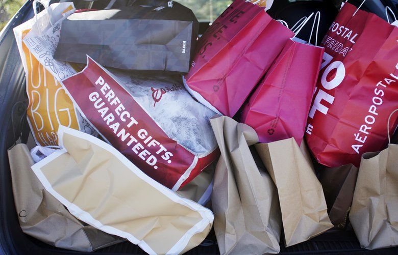 FILE- In this Nov. 23, 2018, file photo shopping bags are stuffed into a car at Prime outlets on Black Friday in Lee, Mass. . (Ben Garver/The Berkshire Eagle via AP, File) MAPIT202 MAPIT202