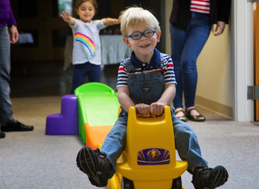 Peter Bennett rides down a ramp at Kindering in Renton. “The kiddos don’t know it, but everything they do here is therapy,” Peter’s mom says. (Ellen M. Banner / The Seattle Times)