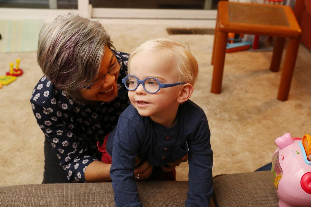 Elda Harada, a physical therapist, helps Arthur Marzinke, 2, develop his motor skills at the Marzinkes’ home. “The goal is always to increase functionality and independence, and the trick is to find the motivation,” she says. (Ken Lambert / The Seattle Times)