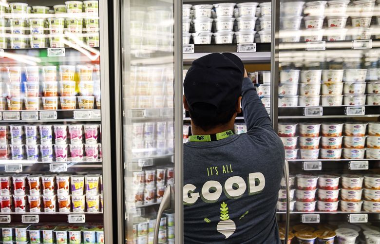 An employee stocks yogurt for sale on the opening day of the 365 by Whole Foods Market store in the Silver Lake neighborhood of Los Angeles, California, U.S., on Wednesday, May 25, 2016. Whole Foods Market Inc., plans to open 10 of the grocery stores in 2017 with a focus on everyday low prices and convenience. Photographer: Patrick T. Fallon/Bloomberg