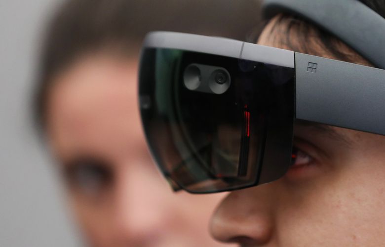 An attendee tests a Microsoft Corp. HoloLens virtual reality (VR) headset on the Microsoft Corp. stand at the Virtual Reality World Congress in Bristol, U.K., on Wednesday, April 12, 2017. Virtual reality proponents say that liberating computing from the confines of glass rectangles will change the way people interact with information. Photographer: Chris Ratcliffe/Bloomberg 700033809