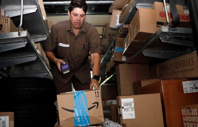 United Parcel Service employee Liz Perez scans an Amazon Prime package for delivery in Miami, Tuesday, July 17, 2018. Amazon Prime Day was launched July 16. The event is in four new countries this year and will be six hours longer than last year’s. (AP Photo/Lynne Sladky)