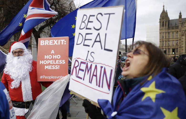 Remaining in the European Union supporters, including one dressed as Santa, hold placards and protest outside the Houses of Parliament in London, Monday, Dec. 10, 2018. British Prime Minister Theresa May looked set Monday to postpone Parliament’s vote on her European Union divorce deal to avoid a shattering defeat, throwing Brexit plans into chaos just weeks after Britain and the bloc finally reached an agreement on the U.K.’s departure. (AP Photo/Matt Dunham) LMD109 LMD109