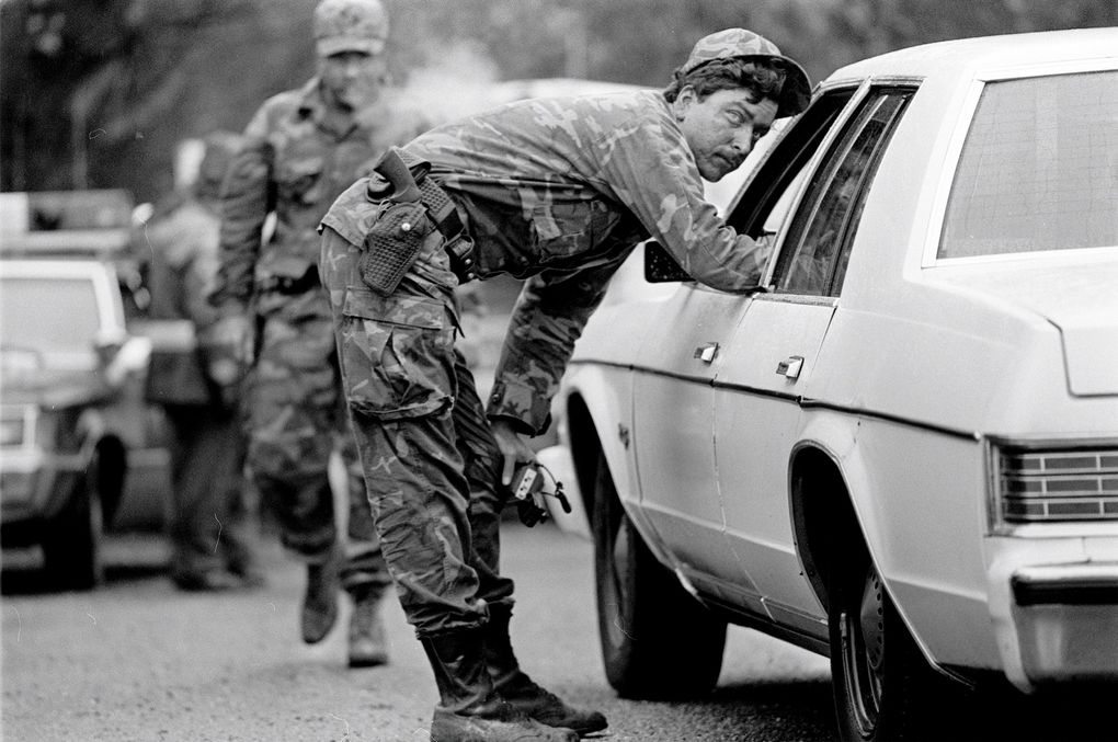 Island County deputies talk to motorists near the site of a standoff and shootout with white supremacists on Whidbey Island in 1984. (Betty Udesen / The Seattle Times)