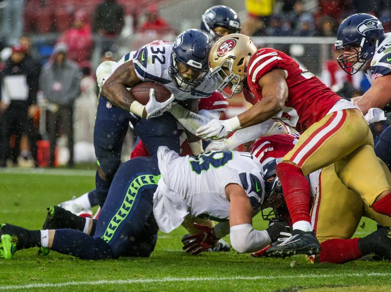 Seattle Seahawks running back Chris Carson gestures while smiling