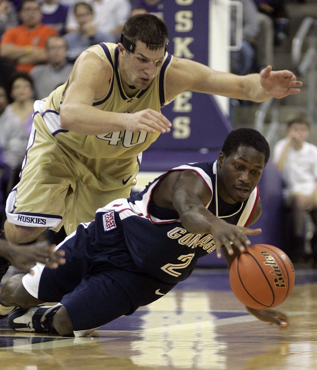 Jon Brockman and Jeremy Pargo dive to the ground for a loose ball.
(Dustin Snipes / The Seattle Times)