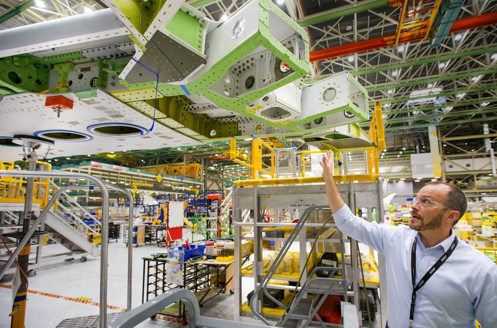 Jason Clark, vice president of 777/777X Operations, points out the crucial hinge on the Boeing 777X that enables the 11-foot wing tip to fold up when parked at an airport gate and to unfold and lock into place before flight. (Mike Siegel / The Seattle Times)