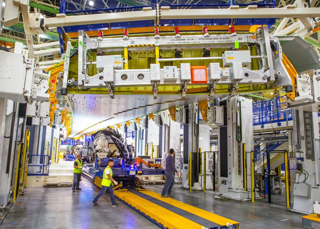 A 108-foot portion of a wing inside one of the Electroimpact-designed 777X wing assembly stations. The fixed-bed robot on tracks (in yellow) travels under the wing to do the drilling and filling. This is the wing of one of the first planes that will be delivered to an airline customer. (Mike Siegel / The Seattle Times)