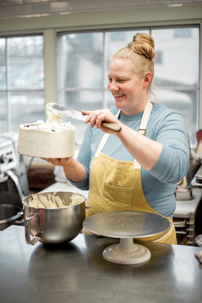 pastry chef girl, baker holds whisk in her hands, cooked cake on