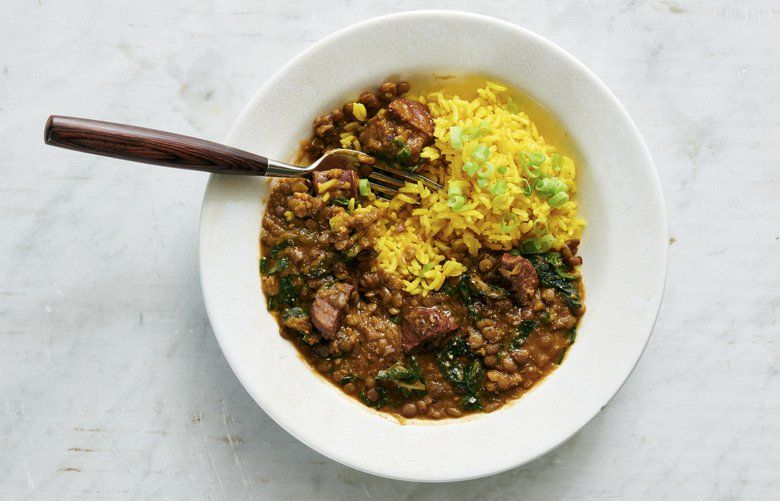 Lentils with chorizo, greens and yellow rice in New York, Dec. 2018. Food styled by Simon Andrews. A stew of lentils, chorizo and greens, served with yellow rice, is hearty, filling and delicious no matter when you have it. (David Malosh/The New York Times) XNYT66 XNYT66