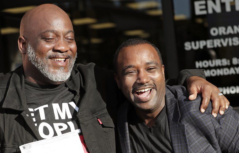 Former felons Desmond Meade, president of the Florida Rights Restoration Coalition, left, and David Ayala, husband of State Attorney Aramis Ayala, celebrate with copies of their voter registration forms after they registered at the Supervisor of Elections office Tuesday, Jan. 8, 2019, in Orlando, Fla. Former felons in Florida began registering for elections on Tuesday, when an amendment that restores their voting rights went into effect. (AP Photo/John Raoux) FLJR111 FLJR111