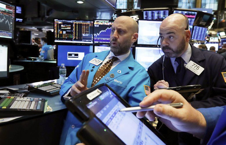 Specialist Meric Greenbaum, left, and trader Fred DeMarco, center, work on the floor of the New York Stock Exchange, Tuesday, Jan. 8, 2019. (AP Photo/Richard Drew)