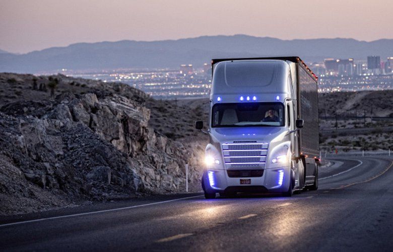 A driver operates a Freightliner truck on a road outside Las Vegas. Freightliner parent Daimer AG is investing more than half a billion dollars into driverless technology. (Daimler AG/TNS) 