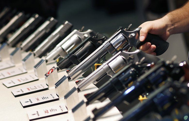 FILE – In this Jan. 19, 2016 file photo, handguns are displayed at the Smith & Wesson booth at the Shooting, Hunting and Outdoor Trade Show in Las Vegas.  (AP Photo/John Locher, File) 