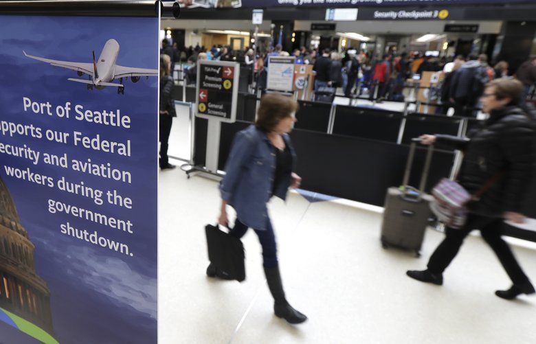 A sign near a TSA security checkpoint states the Port of Seattle’s support for federal government workers, Friday, Jan. 25, 2019, in Seattle. Yielding to mounting pressure and growing disruption, President Donald Trump and congressional leaders on Friday reached a short-term deal to reopen the government for three weeks while negotiations continue over the president’s demands for money to build his long-promised wall at the U.S.-Mexico border. (AP Photo/Ted S. Warren) WATW103 WATW103