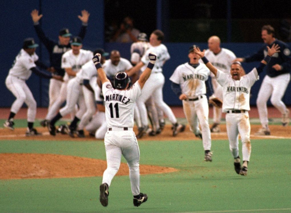 While one group of Mariners gathers around Ken Griffey Jr. at home plate, a second runs out to second base to meet Edgar Martinez whose double to left scored Joey Cora and Griffey for the win in Game 5 of the 1995 American League Division Series. (Dean Rutz / The Seattle Times)