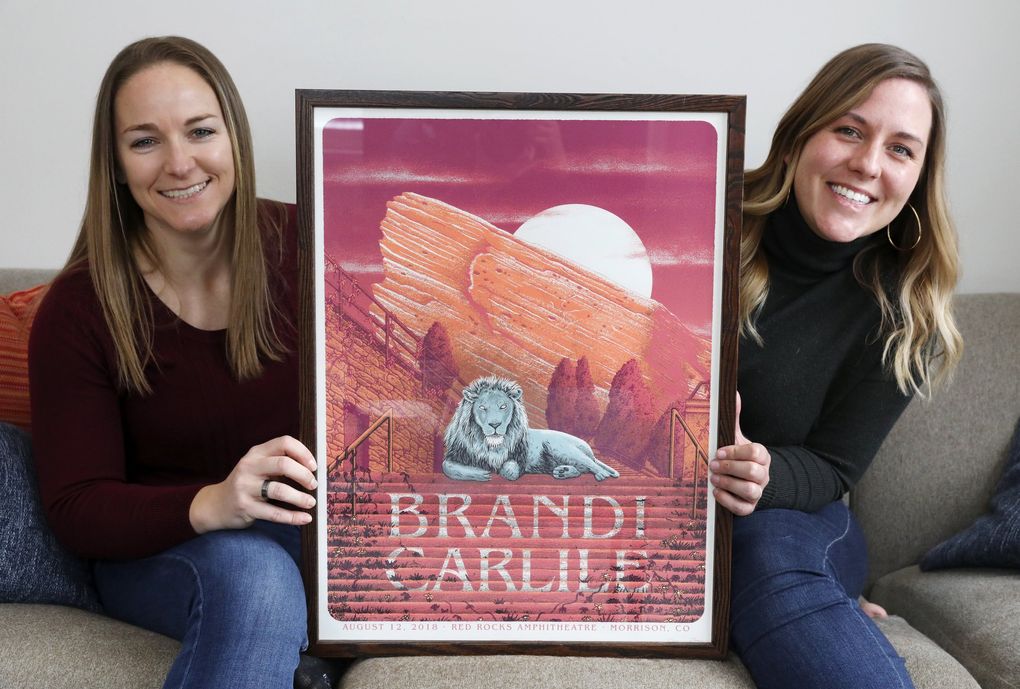 Lisa Nielsen, left, and Karen Gray, right, seen at home in Seattle, got engaged at a Brandi Carlile concert last year. The couple framed the poster from the 2018 Red Rocks show where Nielsen popped the question. They plan to marry this year. (Ken Lambert / The Seattle Times)