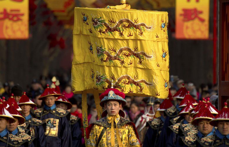 In the Tuesday, Feb. 5, 2019, photo, a performer dressed as an emperor, center, participates in a Qing Dynasty ceremony in which emperors prayed for good harvest and fortune at a temple fair in Ditan Park in Beijing. Chinese people are celebrating the first day of the Lunar New Year on Tuesday, the Year of the Pig on the Chinese zodiac. (AP Photo/Mark Schiefelbein) ASIA308 ASIA308